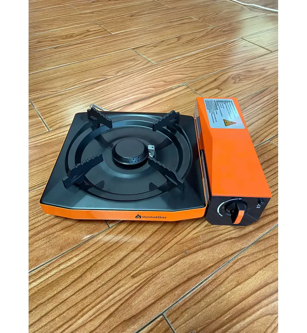 Bếp gas mini di động màu cam phối đen đặt trên sàn gỗ