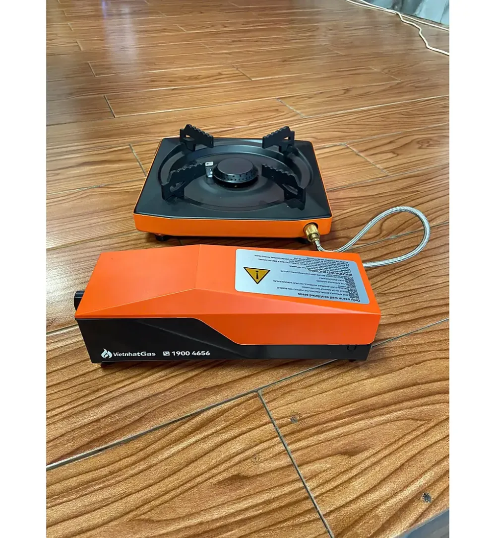 Bếp gas mini cam đen nối ống dẫn với hộp gas rời trên sàn gỗ