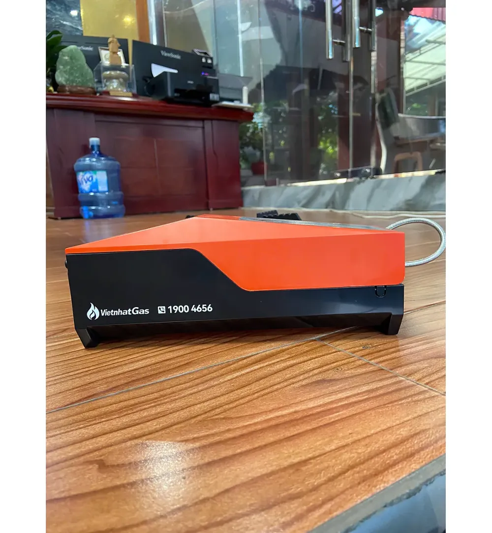 Hộp gas rời màu cam đen của bếp gas mini nối ống dẫn trên sàn gỗ